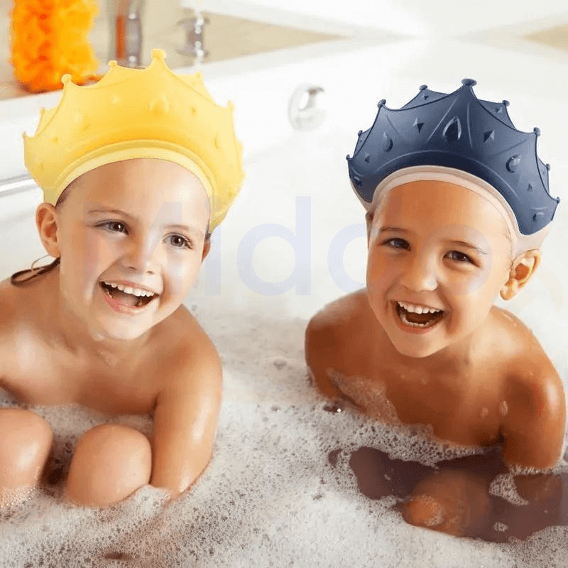 Twee lachende kinderen in bad met gele en blauwe kroonvormige badhoeden.