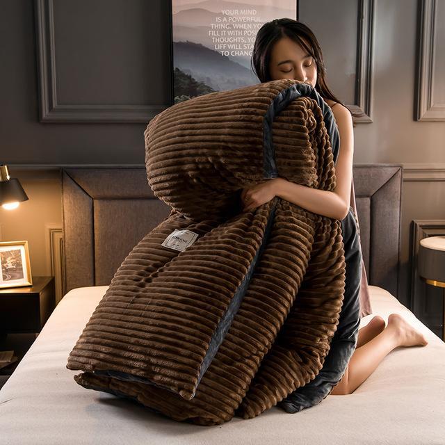 Vrouw knuffelt bruin fluwelen fleece dekbed met overtrek op bed.