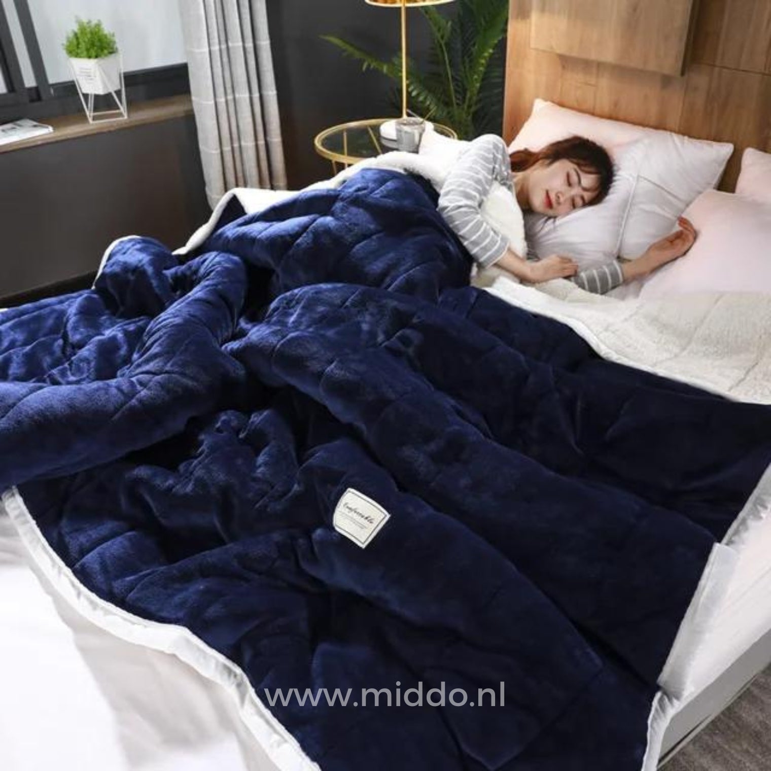 CozyFleece donkerblauw pluche woldeken op bed met slapende persoon