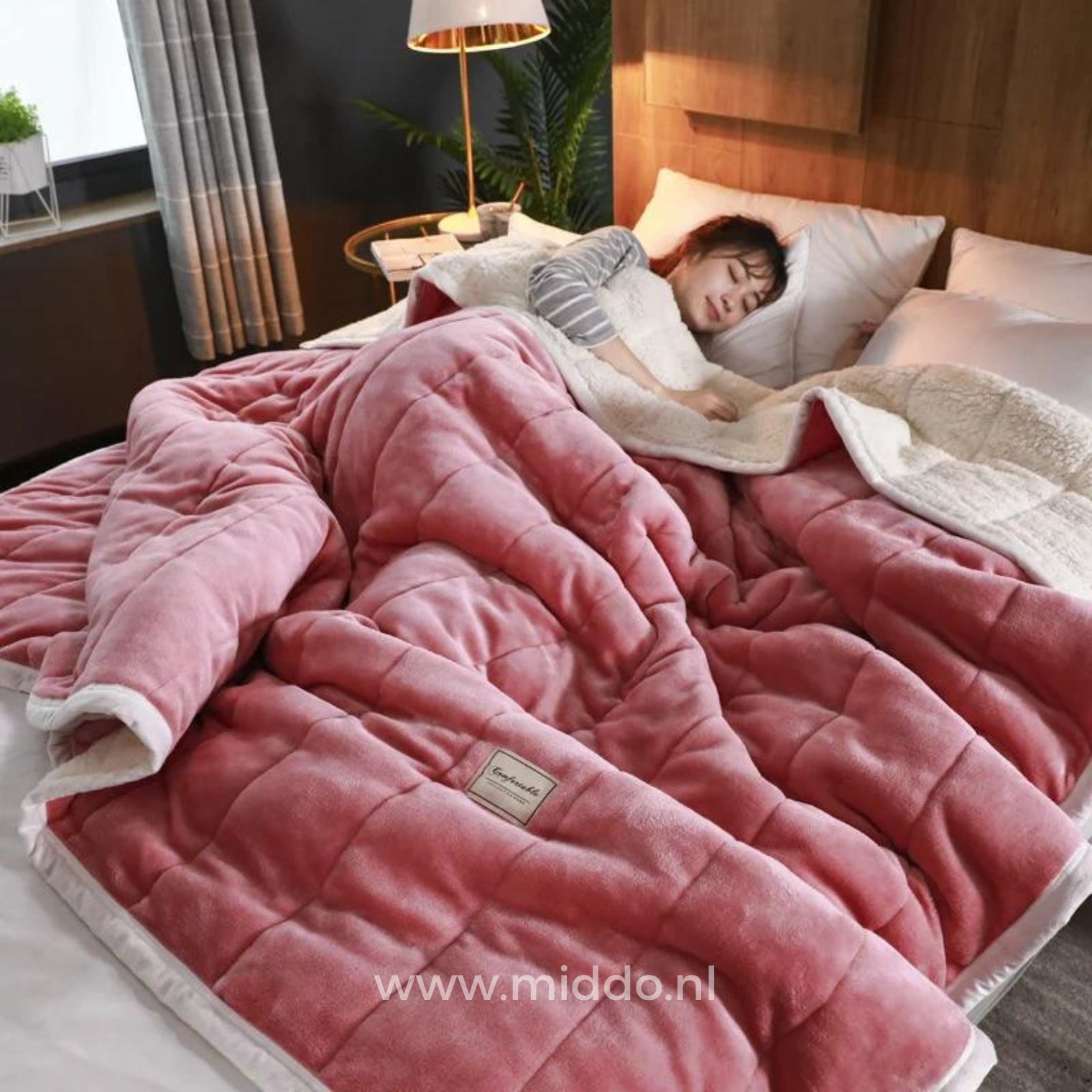 CozyFleece roze pluche woldeken op bed met slapende persoon