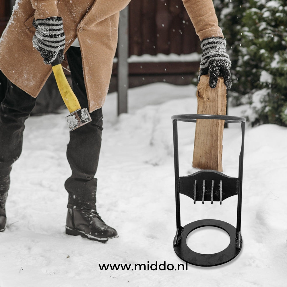 Man met bijtel in zijn hand in de sneeuw die een stuk hout gaat kloven in de slag houtkloofmachine