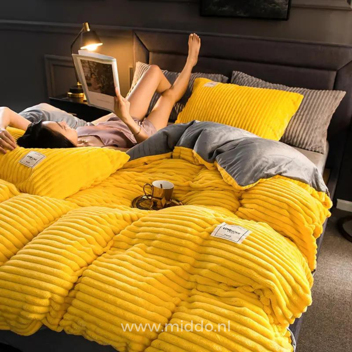 Vrouw ligt op bed met tijdschrift op geel dekbedovertrek