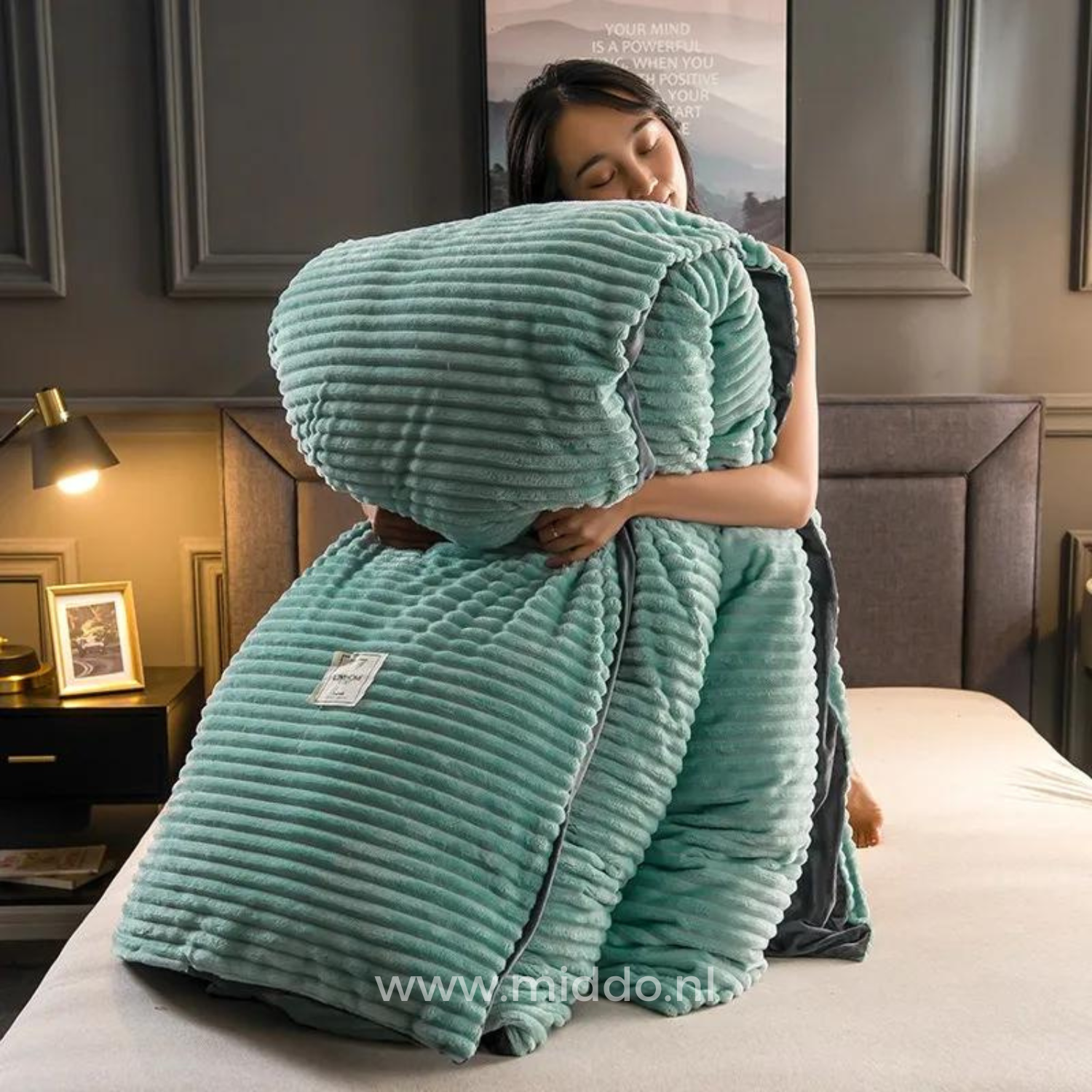 Vrouw met opgevouwen jadegroen dekbedovertrek met dekbed erin op een bed