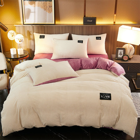 Wit fluwelen fleece dekbedovertrek met roze onderkant op een bed en kussens erop