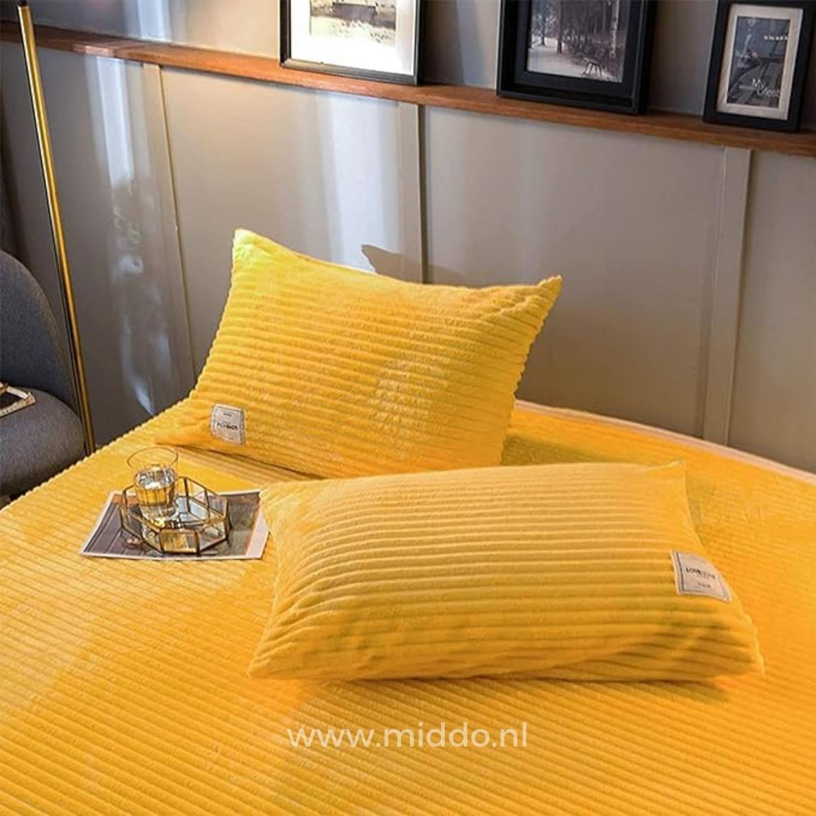 2 kussens met gele kussenslopen op een bed