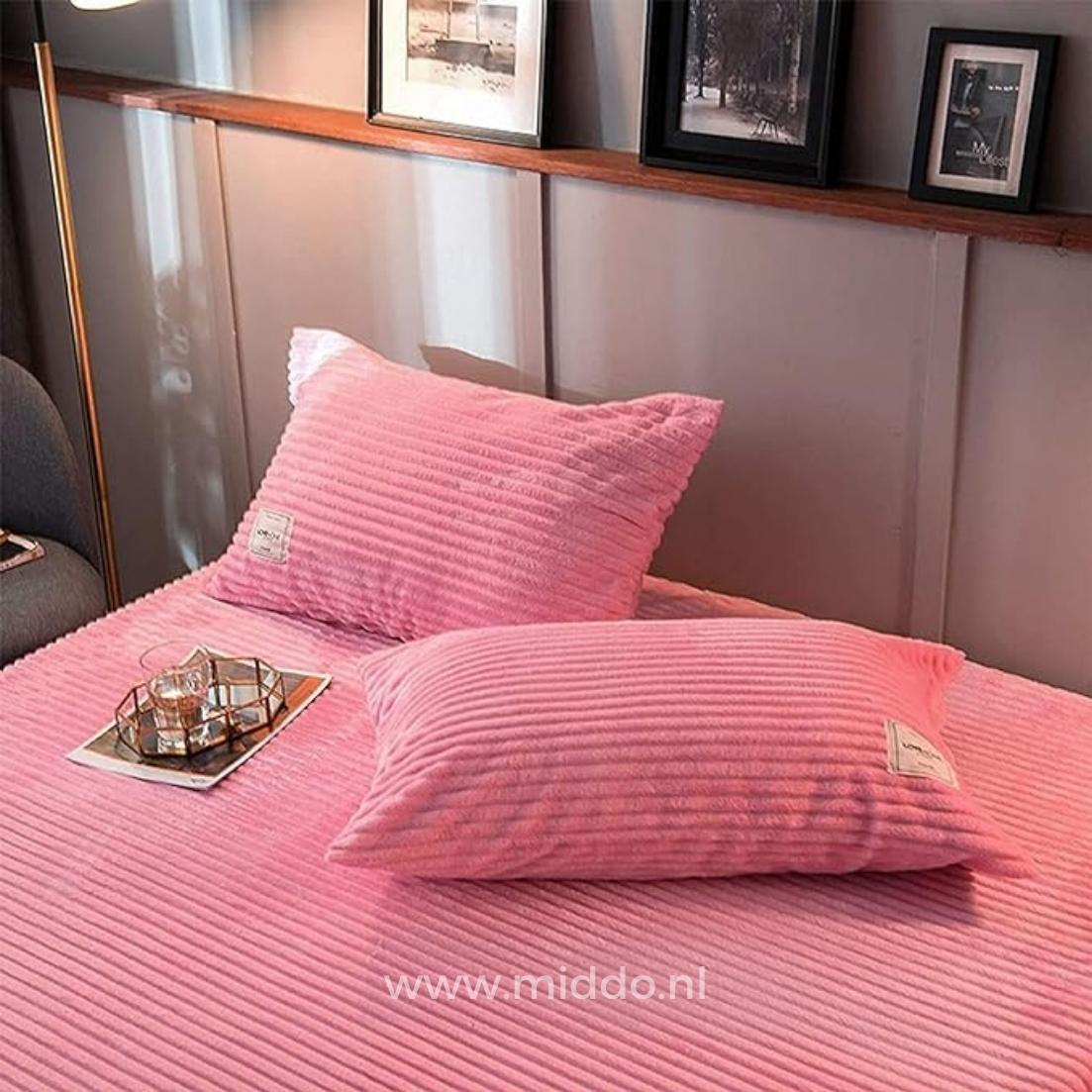 2 kussens met roze kussenslopen op een bed