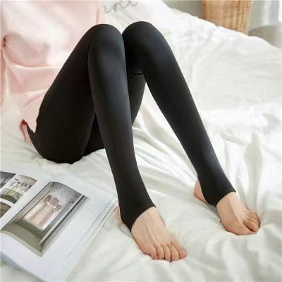 Zwarte panty met open tenen, dame zit op bed.