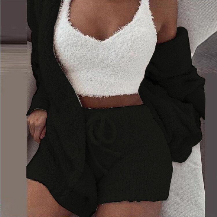 Vrouw in zwarte SheCutie 3-delige comfy set, witte top, shorts, en vest.