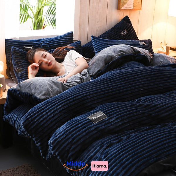 Vrouw slaapt in bed met donkerblauw fleece dekbedovertrek.