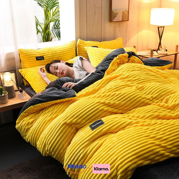 Vrouw slaapt in bed met geel fleece dekbedovertrek.