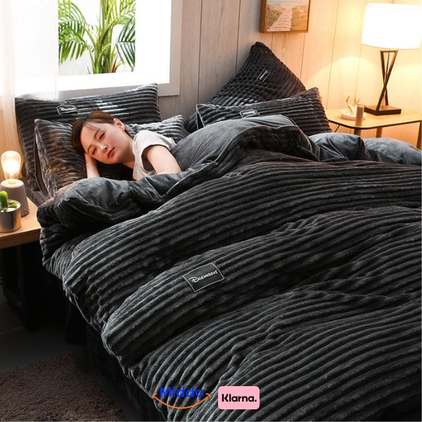 Vrouw slaapt onder donkergrijs fleece dekbedovertrek, naast lamp