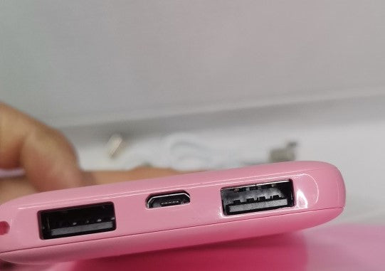 Close-up van Huggy's roze powerbank-aansluitingen.