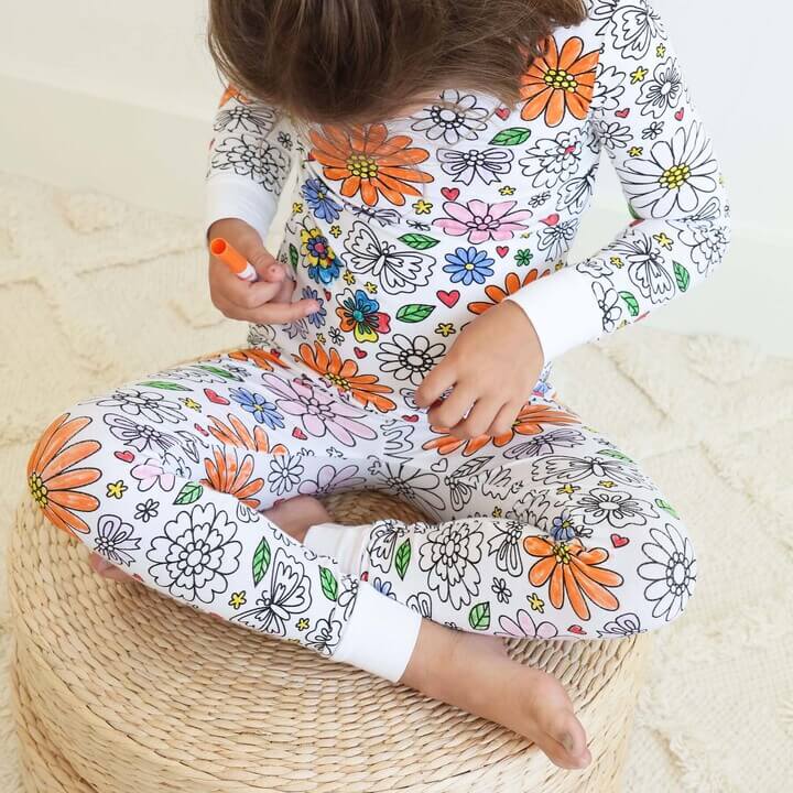 Meisje kleurt een inkleurbare bloemen pyjama in.