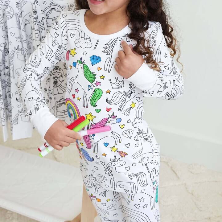 Meisje kleurt een inkleurbare eenhoorn pyjama in.