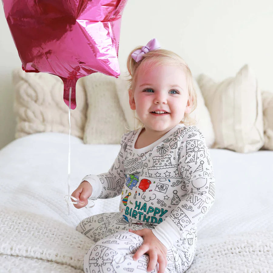 Meisje draagt een inkleurbare verjaardag pyjama met ballonnen.