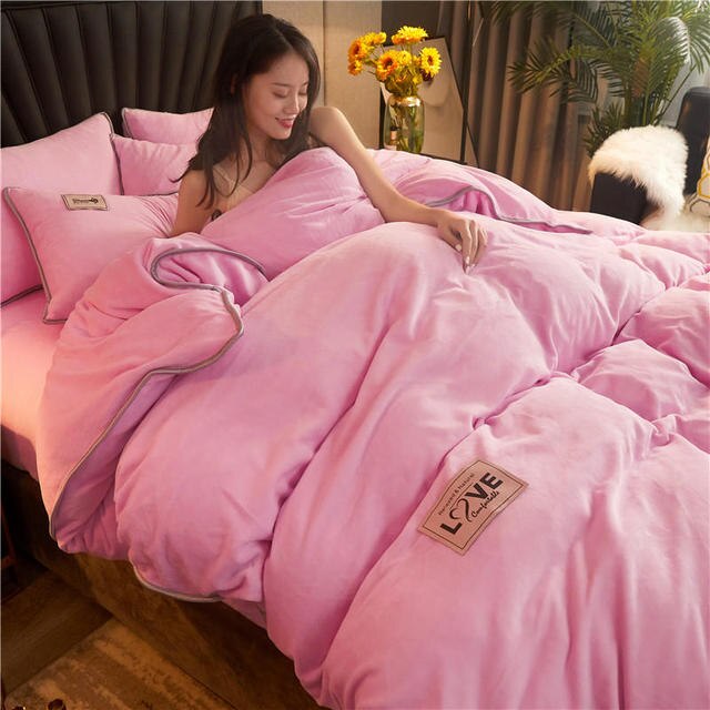 Vrouw in lichtroze fluwelen pluche dekbedovertrek in een gezellig bed