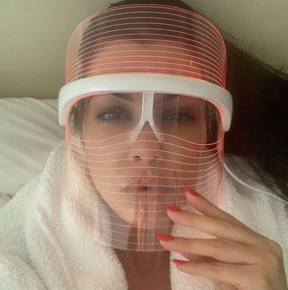 Vrouw draagt LumiGlow LED masker met rood licht voor huidverjonging.