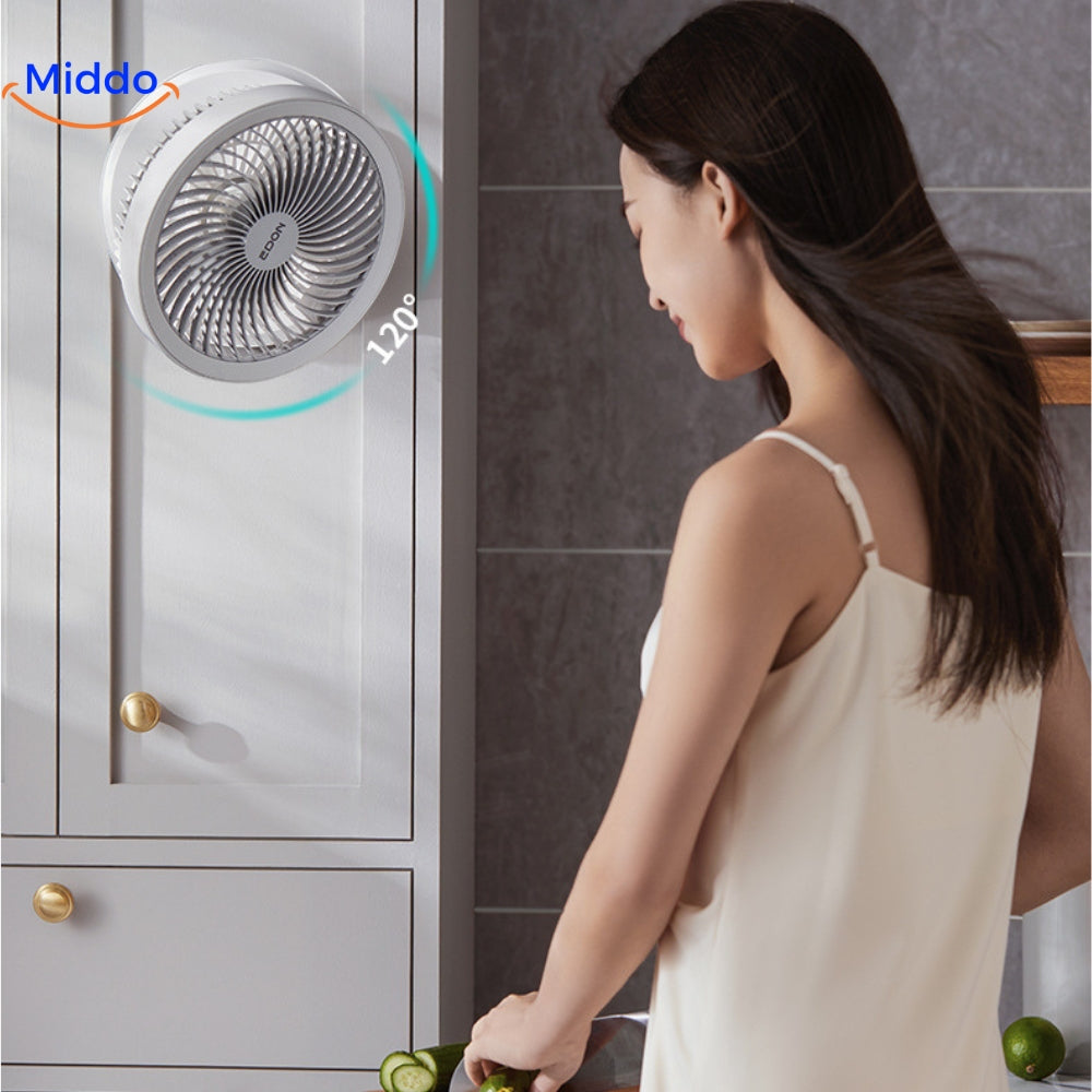 Vrouw geniet van ventilator in keuken met haar wapperend.